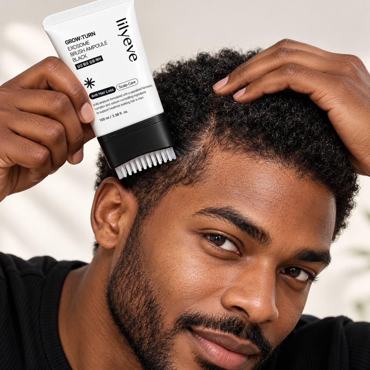 Hombre aplicándose lilyeve Grow:Turn Exosome Brush Ampoule Black sobre el cuero cabelludo